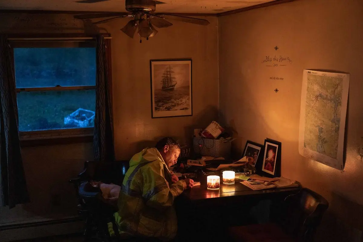 A person working by candlelight in a coastal home