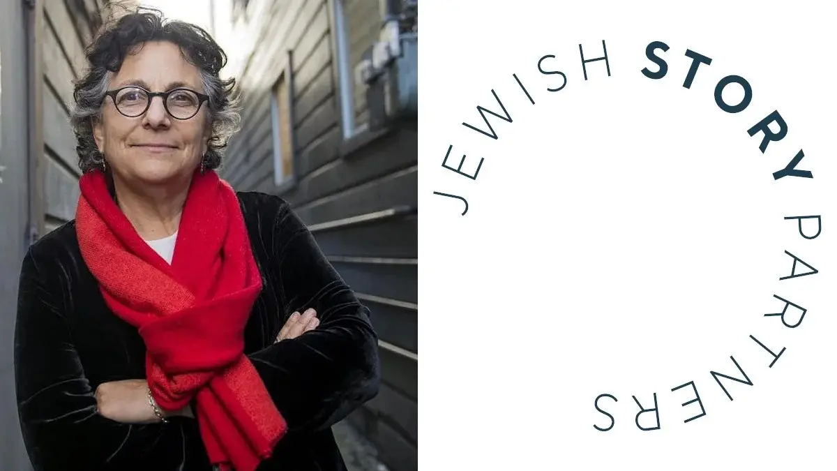 Jewish Story Partners executive director Roberta Grossman beside the organization logo